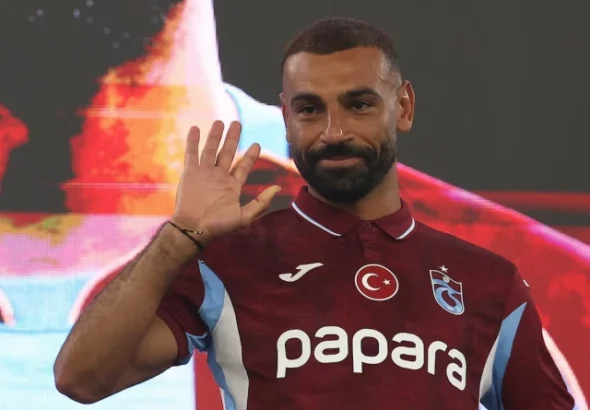 Trabzonspor's new signing Mohamed Salah waving to the fans while wearing the team's burgundy kit.